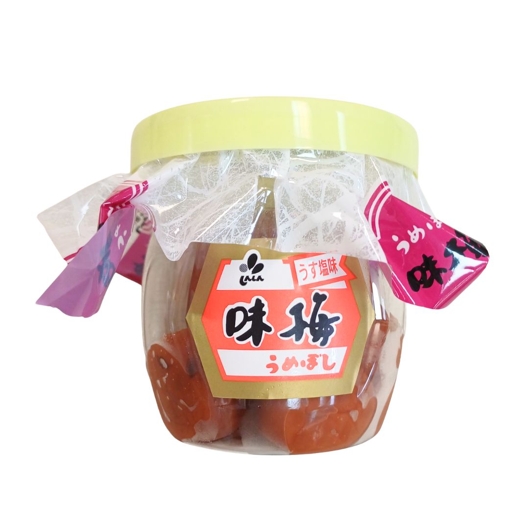 Jar of pickled plums with a yellow lid and red label on a white background