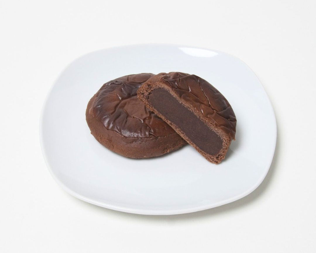 Chocolate cookie with a cut section on a white plate