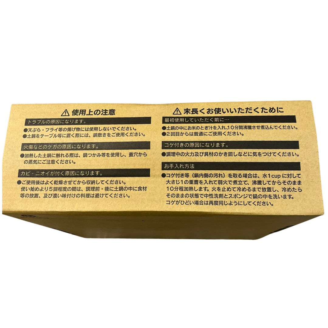 Cardboard box with Japanese text and warning symbols on a white background
